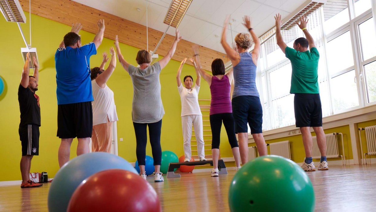 Physiotherapiekurs mit Pezzi Bällen und mehreren Teilnehmern, die im Kreis stehen Physiotherapiekurs mit Pezzi Bällen und mehreren Teilnehmern, die im Kreis stehen