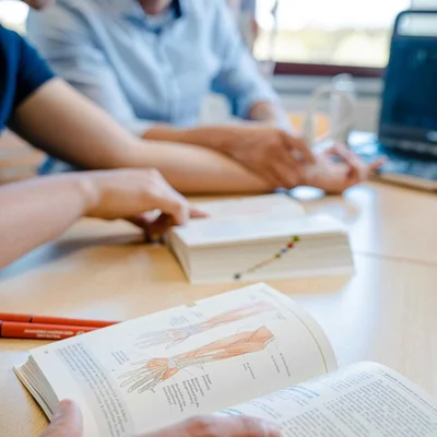 Tisch mit Lehrbüchern und Laptop