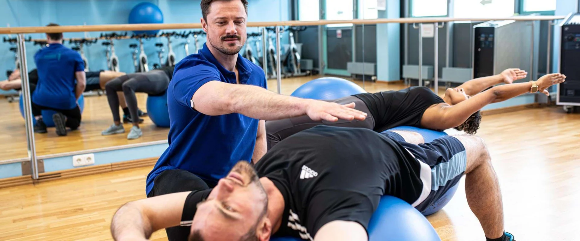 Physiotherapeut der Johannesbad ambulante Reha leitet Kurs mit Pezzibällen