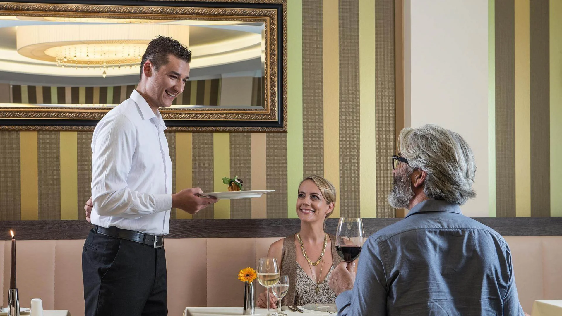 Servicekraft der Johannesbad Hotels bedient Gäste im Restaurant