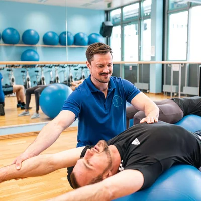 Dozent der Johannesbad Medfachschule erklärt Physiotherapie Übung auf Pezzi-Ball