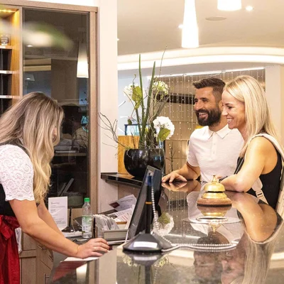Rezeptionistin der Johannesbad Hotels mit Pärchen beim Check-in